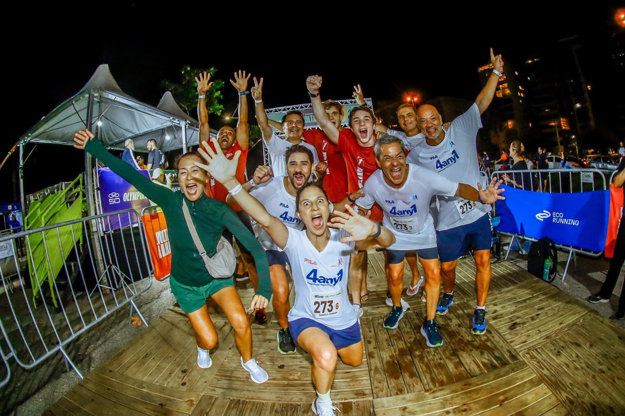 Grupo de corredores comemorando após prova noturna